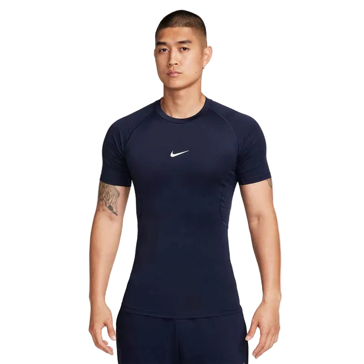 A man wearing a dark navy blue Nike athletic t-shirt with a small white Swoosh logo on the chest, set against a plain light gray background.